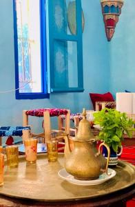 una mesa con una tetera y algunos vasos en ella en Dar Garindi, en Asilah