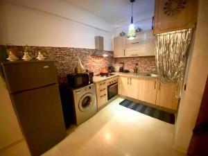 cocina con nevera y lavadora en Splendido appartamento a Gueliz en Marrakech