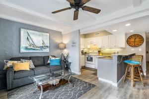 a living room with a couch and a kitchen at Casa de Emdeko 221 in Kailua-Kona