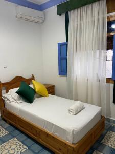 Rúm í herbergi á Hôtel Al Kalaa