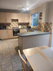 a kitchen with a counter and a table in it at Perfect Place in Walsall/ 4 bedroom / long term workers or family home in Walsall
