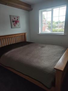 a bedroom with a large bed with a window at Perfect Place in Walsall/ 4 bedroom / long term workers or family home in Walsall