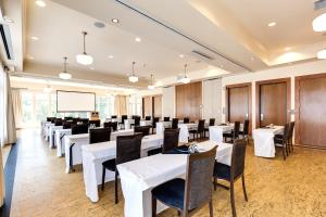 uma sala de jantar com mesas e cadeiras brancas em Hotel Eldorado at Eldorado Resort em Kelowna