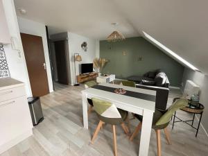 ein Wohnzimmer mit einem weißen Tisch und Stühlen in der Unterkunft T2 cœur de ville thème bohème in Rodez