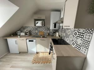 a small kitchen with white cabinets and a sink at T2 cœur de ville thème bohème in Rodez