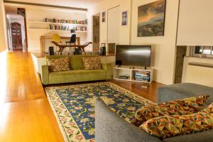 ein Wohnzimmer mit einem grünen Sofa und einem TV in der Unterkunft Casa do Becco in Angra do Heroísmo