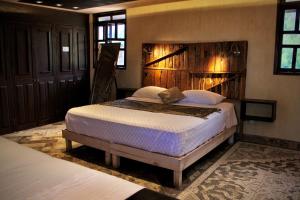 een slaapkamer met een groot bed met een houten hoofdeinde bij Casa Hala LOFT & SPA LUXURY in León