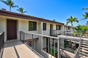 uma varanda de uma casa com palmeiras em Country Club Villas 302 em Kailua-Kona