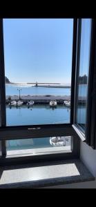 ein Fenster mit Blick auf einen Hafen mit Booten im Wasser in der Unterkunft «ΑΓΝΑΝΤΙΟ l» Δωμάτιο με μοναδική θέα! in Mirina