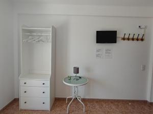 ポルト・コーヴォにあるApartamentos Guiomar Camposの白い部屋(テーブル、壁掛けテレビ付)