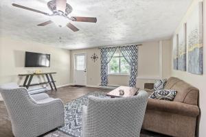 a living room with a couch and a ceiling fan at Large Home Sleeps 24! Dogs Ok! in Lansing