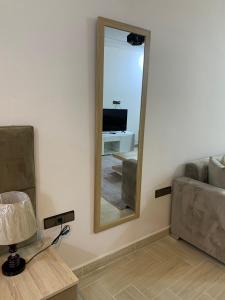 einen Spiegel in einem Zimmer mit Sofa und Tisch in der Unterkunft Hotel la Perle d'Arfoud in Erfoud