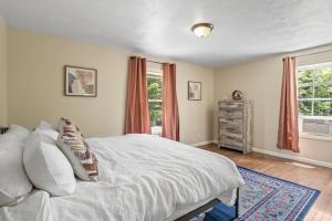 a bedroom with a large bed and two windows at Large Home Sleeps 24! Dogs Ok! in Lansing