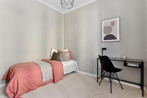 a bedroom with a bed with a desk and a chair at Beautiful apartment in the heart of Oslo! in Oslo