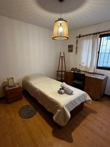 Un dormitorio con una cama con un osito de peluche. en BlackBird apartamentos en San Carlos de Bariloche