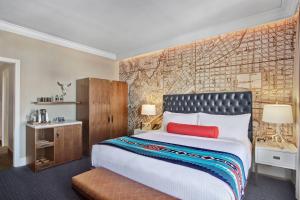 a bedroom with a large bed and a map wall at Hotel Paso Del Norte, Autograph Collection in El Paso