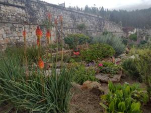 un jardín con flores y una pared de piedra en Lujosa Casa Quinta en Naturaleza Andina en Iza