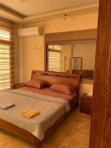 1 dormitorio con 1 cama grande y espejo en The Pine Tree Chalet, en Jerash