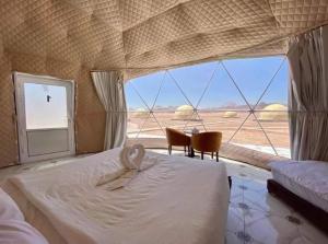 Wadi Rum Gulf camp في العقبة: غرفة نوم بسرير ومنظر صحراوي