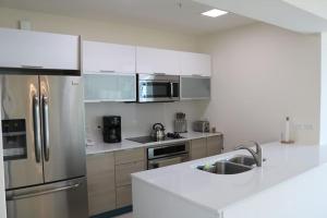 a kitchen with a stainless steel refrigerator and a sink at 14B Luxury Oceanview Playa Bonita Resort Panama in ArraijÃ¡n