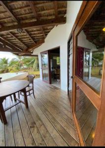 una gran terraza de madera con mesa y sillas en CHEZ TAUA maison isolée pas de wifi ni bus en Opoa