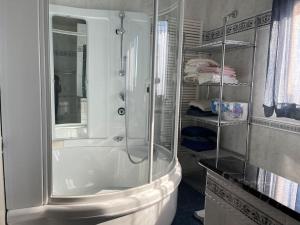 een witte badkamer met een douche en een wastafel bij Villa Duomo Mare in Massa Marittima