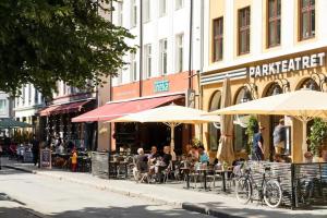 um grupo de pessoas sentadas em mesas sob guarda-chuvas em Beautiful apartment in the heart of Oslo! em Oslo