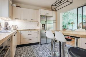 uma cozinha com armários brancos e bancos brancos em Stunning family home in Versailles - Welkeys em Versailles