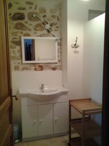 een badkamer met een wastafel en een spiegel bij Le Mas de la Musardiere chambres d hotes in Les Assions