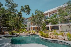 ein Apartmenthaus mit einem Pool vor einem Gebäude in der Unterkunft Erena Tulum in Tulum