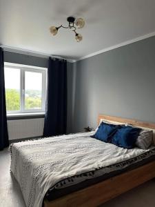 a bedroom with a bed with blue walls and a window at Apartament for rent in Căuşeni