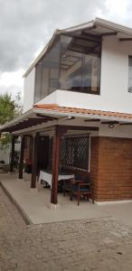 a building with a table and benches in front of it at Estancia el Capulí in Cuenca
