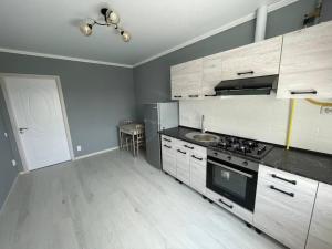 a kitchen with wooden cabinets and a stove top oven at Apartament for rent in Căuşeni
