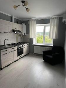 a kitchen with a black chair and a stove at Apartament for rent in Căuşeni