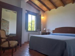 ペルージャにあるAgriturismo La Bullettaのベッドルーム1室(ベッド1台、窓、椅子付)