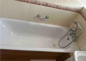 a white bath tub with a shower in a bathroom at 3Bed Apartment Pimlico London in London