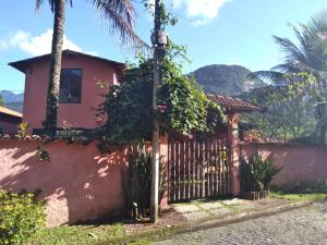 una casa con una recinzione e una palma di Guapimirim Casa de Campo a Guapimirim