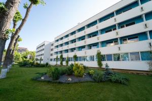 an apartment building with a garden in front of it at Hotel Apollo in Mamaia