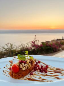 a plate of food on a table with a view of the ocean at Deadsea OCTAGON in Madaba