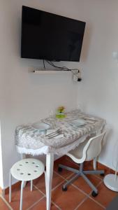 a table with two chairs and a television on a wall at Villa Lucía in Alhaurín de la Torre