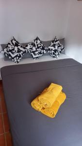 ein Bett mit zwei gelben Handtüchern und schwarzen und weißen Kissen in der Unterkunft Villa Lucía in Alhaurín de la Torre