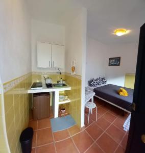 eine kleine Küche mit einem Tisch und einem Bett in einem Zimmer in der Unterkunft Villa Lucía in Alhaurín de la Torre