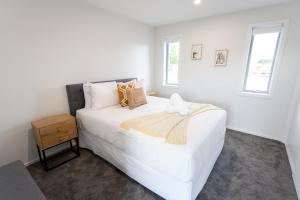 a white bedroom with a white bed and a window at Boundary Retreat Twizel in Twizel