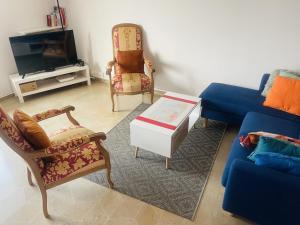un soggiorno con divano blu e sedie di Chambre privée - Place Verdun Tours a Tours