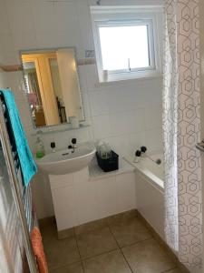 a bathroom with a sink and a tub and a mirror at Home with a view in Liverpool