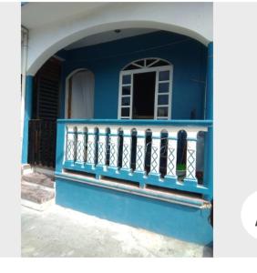 ein blaues Haus mit einem Balkon und einem Fenster in der Unterkunft Casa B&V in Isla Mujeres