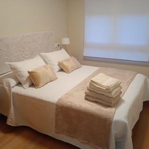 a bedroom with a bed with towels on it at Amaral Miramar in Boiro