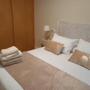 1 dormitorio con 1 cama con sábanas y almohadas blancas en Amaral Miramar, en Boiro