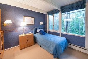 a blue bedroom with a bed and a window at Elegant Lodge with Hot Tub Walk to Highland Lifts in Aspen