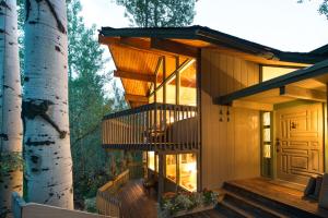 a house in the woods with a tree at Elegant Lodge with Hot Tub Walk to Highland Lifts in Aspen